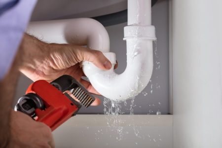 close up,of,male,plumber,fixing,white,sink,pipe,with,adjustable